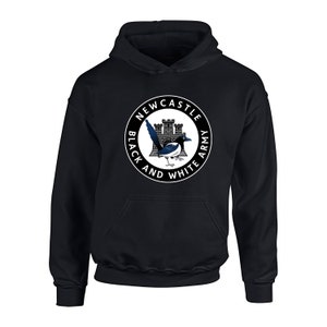Pu&ograve; includere: Felpa con cappuccio nera con un logo circolare bianco che presenta una gazza, un castello e il testo "Newcastle Black and White Army".