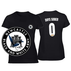 Puede incluir: Camiseta negra con un dise&ntilde;o circular que presenta una urraca, un castillo y el texto "NEWCASTLE BLACK AND WHITE ARMY". La parte trasera de la camiseta muestra "DAYS SOBER" sobre el n&uacute;mero "0" con dos jarras de cerveza.