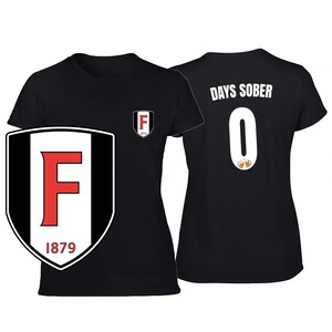 May include: Black t-shirt with the text "DAYS SOBER 0" on the back and a shield logo with the letter "F" on the front. The logo is red and white with the year 1879.