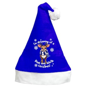 May include: A royal blue Christmas hat with a white pom-pom and brim. The hat features a reindeer graphic wearing a blue and white scarf, surrounded by snowflakes. Text on the hat reads "I'm dreaming of a Blue and White Christmas!"