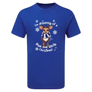 May include: Royal blue t-shirt featuring a cartoon reindeer wearing a blue and white scarf, surrounded by snowflakes. The text "I'm dreaming of a Blue and White Christmas!" is printed on the shirt.