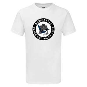 以下が含まれることがあります： 黒と白の円形のグラフィックが施された白いTシャツ。グラフィックには、カササギ、城、そして「Newcastle Black and White Army」というテキストが描かれています。