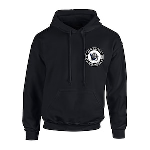 May include: Black hooded sweatshirt with a white circle logo featuring a black and white magpie, a castle, and the text "Newcastle Black and White Army".