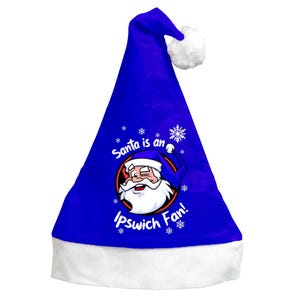 May include: A royal blue Santa hat with a white brim and a white pom-pom. The hat features a graphic of Santa Claus winking, surrounded by snowflakes, and the text "Santa is an Ipswich Fan!"