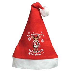 Könnte beinhalten: Ein roter Weihnachtsmannhut mit weißem Rand und weißem Bommel. Der Hut zeigt eine Grafik eines Rentiers mit einem rot-weiß gestreiften Schal und dem Text "I'm dreaming of a Red and White Christmas!"