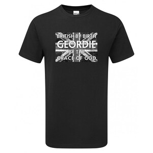 May include: Black t-shirt with a distressed Union Jack graphic. The graphic includes the text "BRITISH BY BIRTH GEORDIE BY THE GRACE OF GOD" in white lettering. The shirt is a crew neck style.