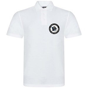 May include: White polo shirt with a black and white circular logo featuring a castle, a bird, and the text "Newcastle Black and White Army".