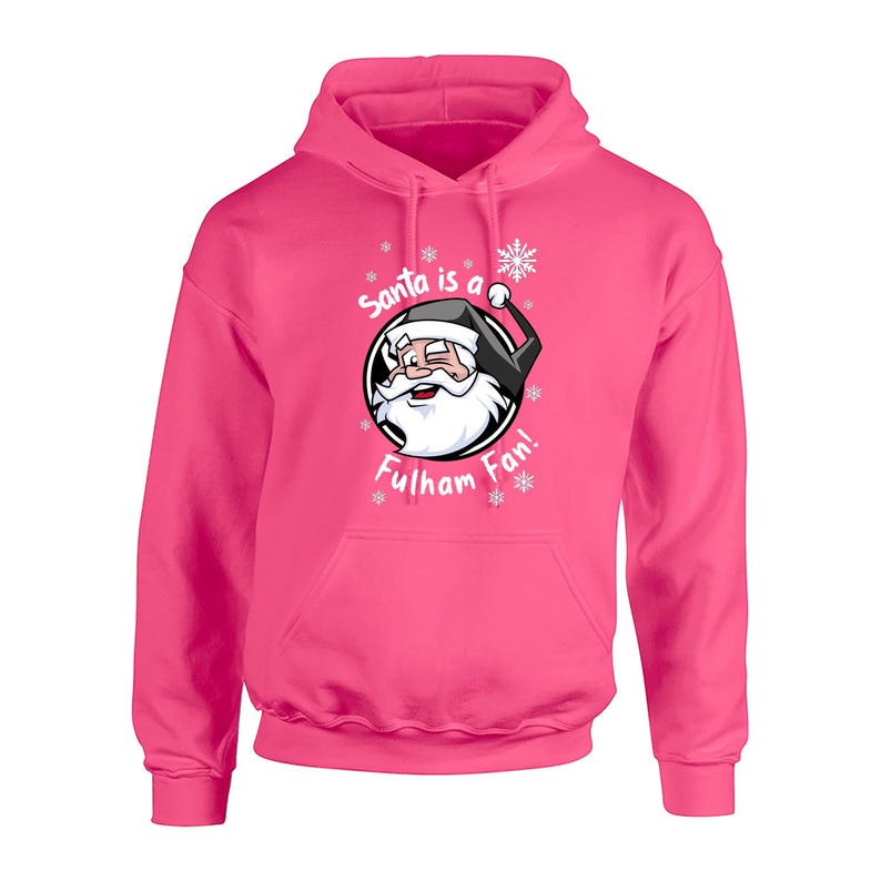 May include: Pink hooded sweatshirt with a white graphic of Santa Claus wearing a black hat and a white beard. The graphic says "Santa is a Fulham Fan!" with snowflakes around the graphic.