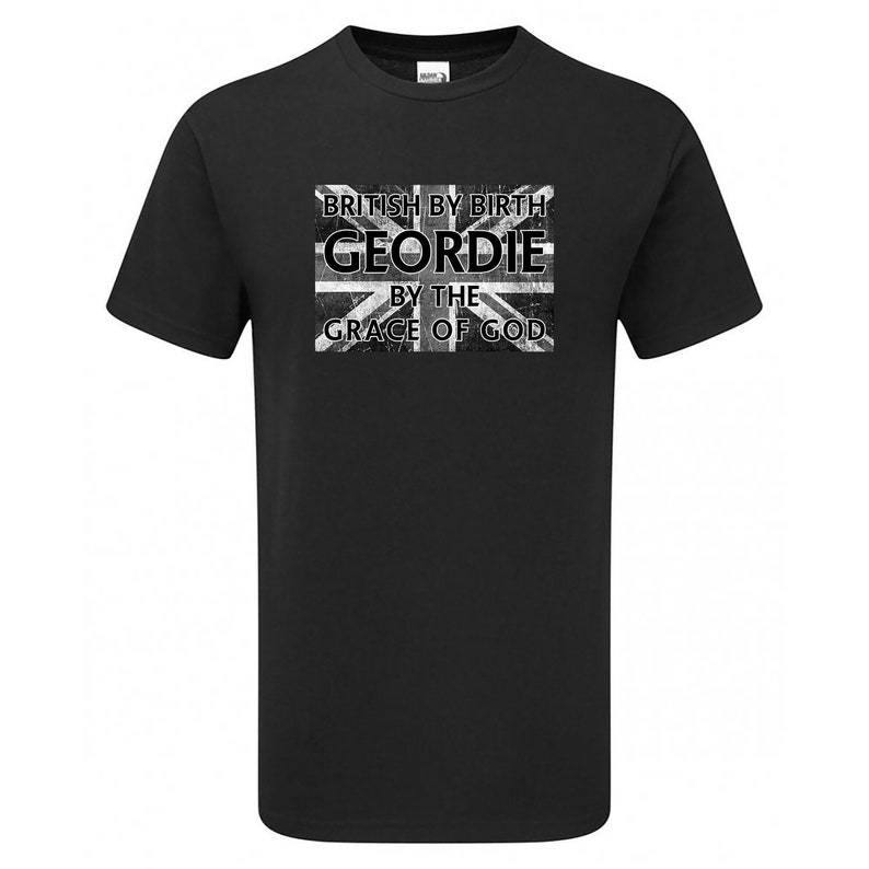 May include: Black t-shirt with a distressed Union Jack graphic and text that reads "BRITISH BY BIRTH GEORDIE BY THE GRACE OF GOD". The shirt is a crew neck style.