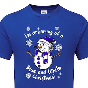 Könnte beinhalten: Königsblaues T-Shirt mit einem Schneemann-Motiv in Blau und Weiß. Der Schneemann trägt einen Hut und einen Schal, und der Text lautet "I'm dreaming of a Blue and White Christmas!"