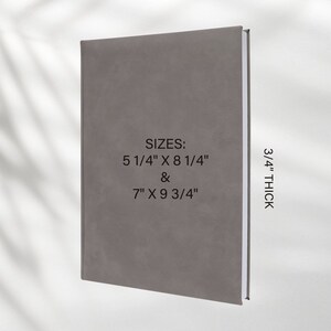 May include: A gray, textured journal with the text "SIZES: 5 1/4" X 8 1/4" & 7" X 9 3/4" 3/4" THICK" printed on the front cover.