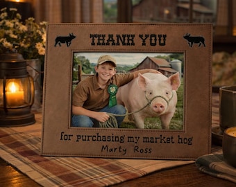 May include: Brown picture frame with a photo of a boy and a pig. The frame has the words "THANK YOU" and "for purchasing my market hog Marty Ross" etched into it. Two black pig silhouettes are on the frame.
