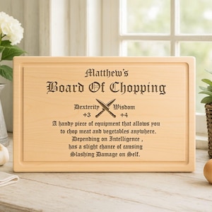 May include: A rectangular wooden cutting board with the text "Matthew's Board Of Chopping" and humorous text about chopping meat and vegetables. The board has a carved edge and is displayed on a light-colored surface.