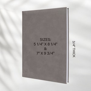 Pu&ograve; includere: Un diario grigio testurizzato con il testo "SIZES: 5 1/4" X 8 1/4" & 7" X 9 3/4" 3/4" THICK" stampato sulla copertina.