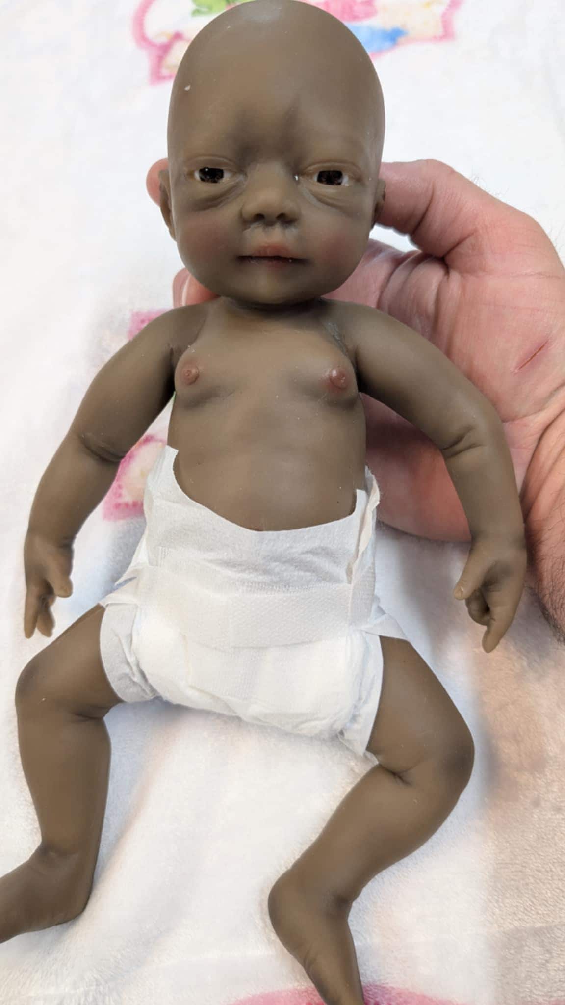 "Afroamerikanische Ganzkörper-Silikon-Babypuppe ""Quinn"" mit abnehmbaren Augen."