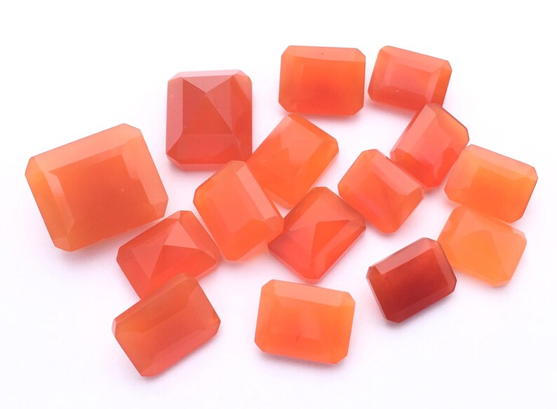 Puede incluir: Una colecci&oacute;n de 12 piedras preciosas de cornalina naranja, talladas en forma rectangular. Las piedras son lisas y pulidas, con un tono naranja c&aacute;lido.