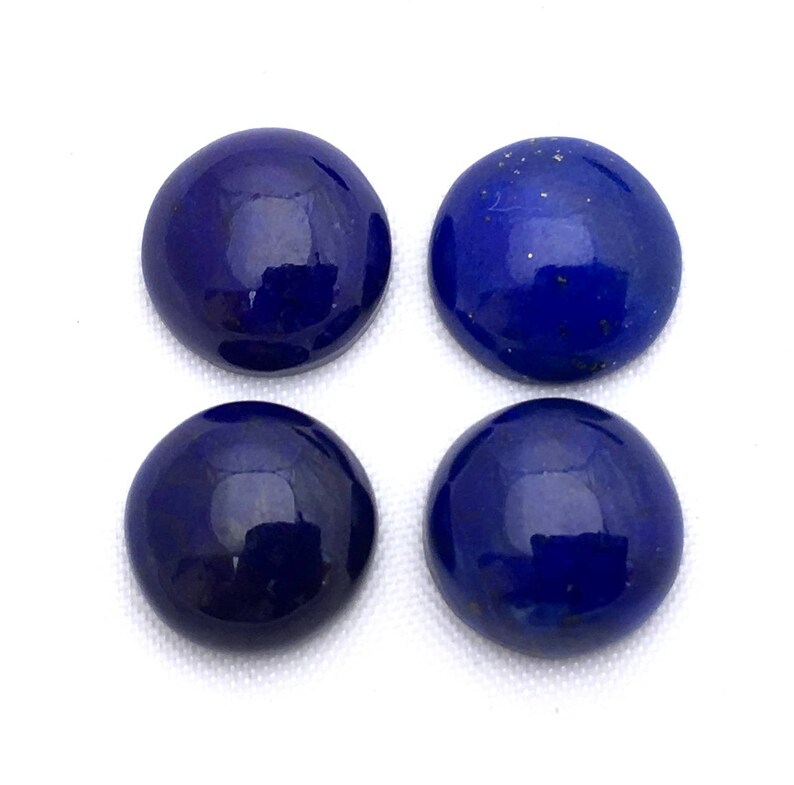 May include: Four round, smooth, dark blue lapis lazuli cabochons. The cabochons are polished and have a slight sparkle.