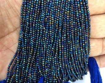 May include: A strand of iridescent black faceted gemstone beads. The beads are small and round, and they have a metallic sheen. The strand is approximately 16 inches long and is strung on a clear elastic cord.
