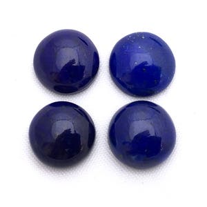 May include: Four round, smooth, dark blue lapis lazuli cabochons. The cabochons are polished and have a glossy finish.