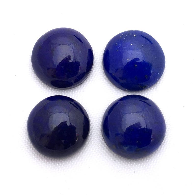 May include: Four round, smooth, dark blue lapis lazuli cabochons. The cabochons are polished and have a glossy finish.