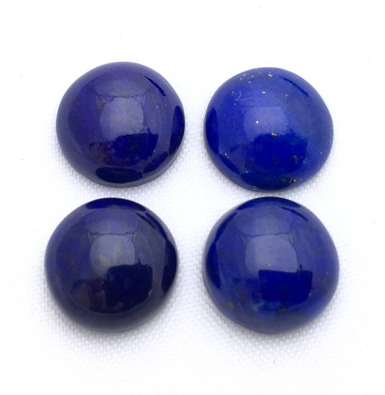 May include: Four round, smooth, dark blue lapis lazuli cabochons. The cabochons are polished and have a glossy finish.