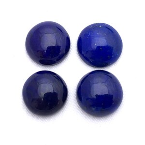 May include: Four round, smooth, dark blue lapis lazuli cabochons. The stones are polished and have a glossy finish.