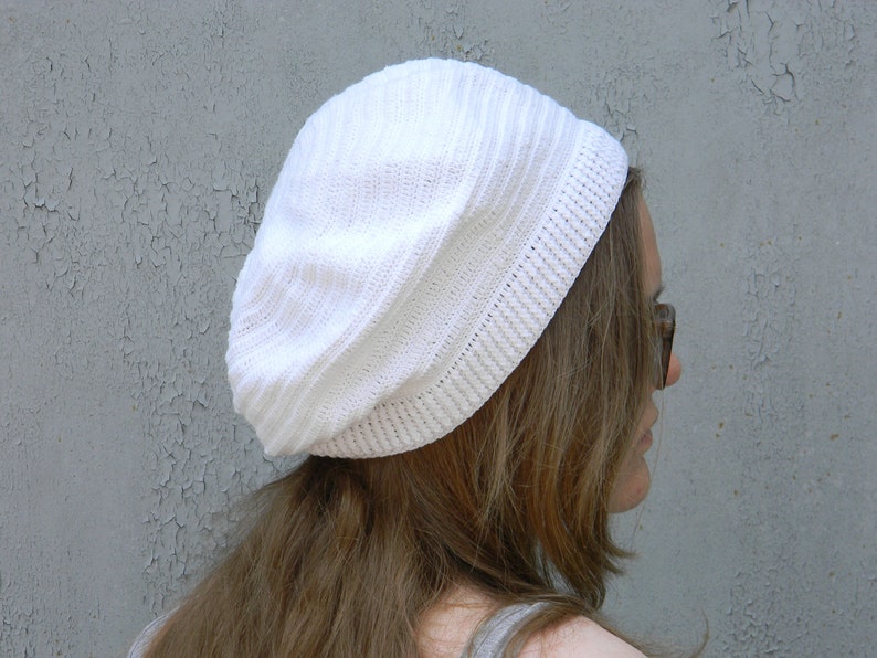 May include: A white crocheted beanie hat with a slouchy fit.