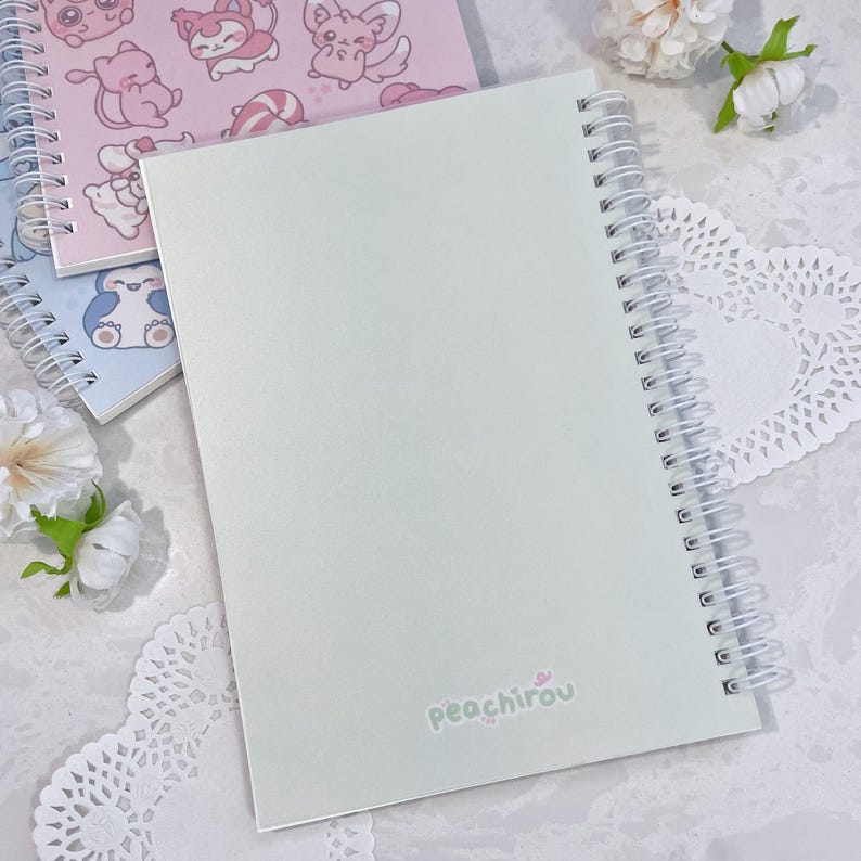 May include: A light green spiral bound notebook with the text "peachirou" printed on the back cover.