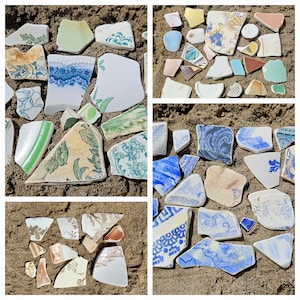 Könnte beinhalten: Eine Ansammlung farbenfroher, zerbrochener Keramikteile mit floralen und geometrischen Mustern, auf Sand verstreut. Die Fragmente zeigen Farbtöne von Blau, Grün, Weiß und Braun und erzeugen einen mosaikartigen Effekt. Einige Teile haben sichtbare Kanten und Kurven.