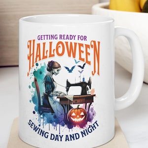 May include: White ceramic mug with a Halloween-themed design. The mug features the text "Getting Ready for Halloween" and "Sewing Day and Night". The design includes a skeleton sewing, bats, and a jack-o'-lantern.