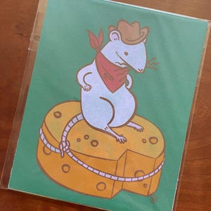 Puede incluir: Ilustración de dibujos animados de un ratón azul claro con sombrero de vaquero y pañuelo rojo, sentado sobre un gran trozo de queso. El queso es amarillo con agujeros y una cuña faltante. El fondo es verde.