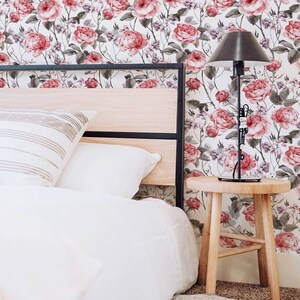 Bedroom with a pink rose pattern wallpaper in the background.
