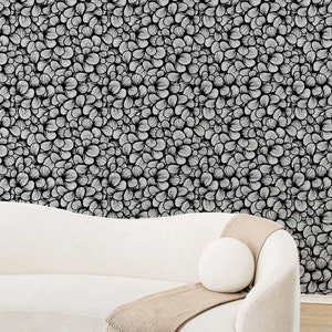 Design sofa in a subtle cream color front of a bold art deco inspired busy pattern.