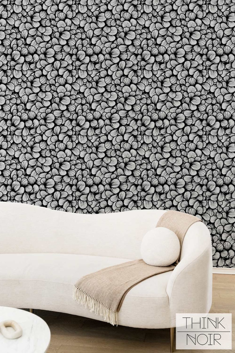 Design sofa in a subtle cream color front of a bold art deco inspired busy pattern.