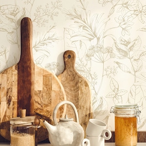 May include: A white ceramic teapot with a brown wooden lid, two white ceramic mugs, a glass jar with a brown wooden lid filled with brown sugar, a glass jar with a metal lid filled with honey, and two wooden chopping boards against a white background with a floral pattern.