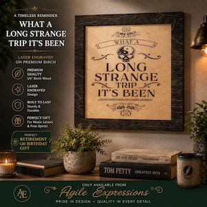 May include: A square wall sign made of 1/4 inch birch wood with a dark frame and a light center panel. The sign features a laser-engraved skull with a yin-yang symbol on its forehead and the text: WHAT A LONG STRANGE TRIP IT'S BEEN.
