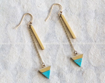 Peut inclure: Une paire de boucles d'oreilles pendantes dorées avec des breloques triangulaires turquoise et des accents de barre dorée.