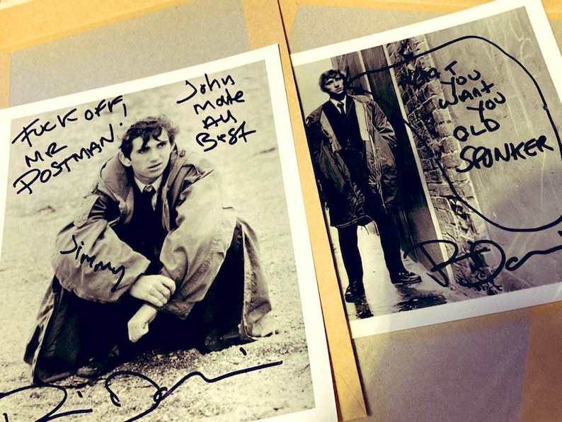 May include: Two black and white photographs featuring a man in a coat. One photo has the text "Fuck off, Mr. Postman" and "Jimmy" written on it. The other photo has the text "I want you old sponker". Both photos are signed.