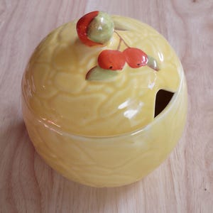Vintage yellow jam pot decorated with orange fruit