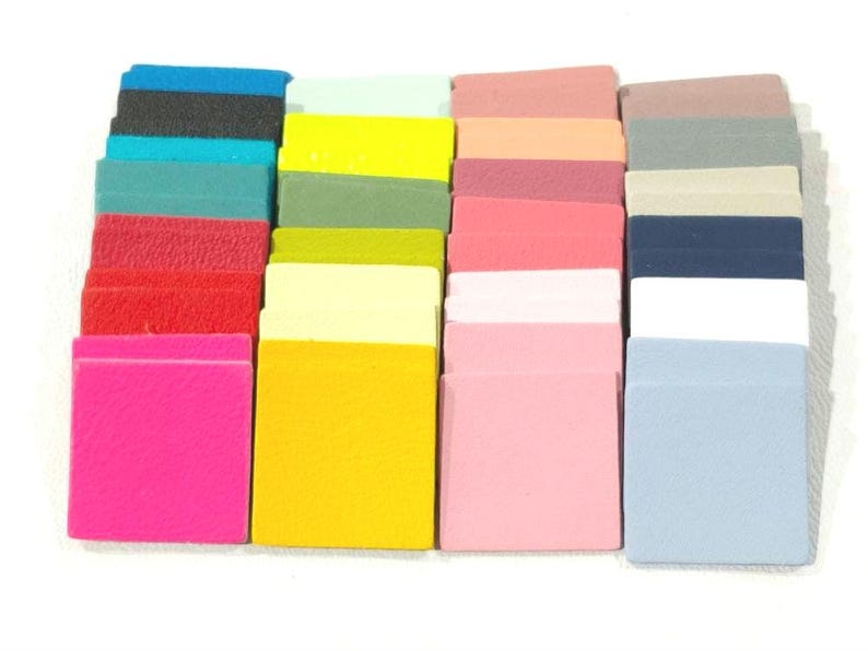 May include: A collection of 24 small, square fabric swatches in various colors, including pink, yellow, blue, green, and red. The swatches are arranged in rows and columns.