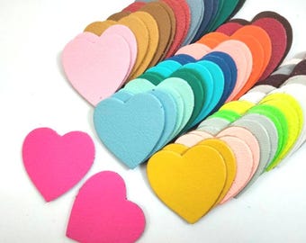 May include: A collection of colorful felt heart shapes in various shades of pink, blue, green, yellow, orange, and red. The hearts are arranged in a semi-circle pattern, with the largest heart at the top and the smallest hearts at the bottom.