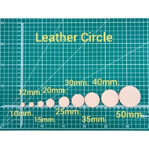 May include: A collection of circular leather pieces in various sizes, ranging from 10mm to 50mm, displayed on a green grid cutting mat. The text "Leather Circle" is visible. Ideal for crafting and leatherwork projects.