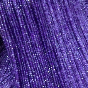 May include: A strand of purple amethyst beads, each bead is square shaped with a faceted finish.