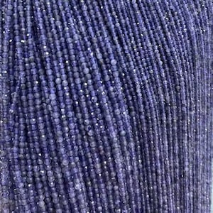 Peut inclure: Un brin de petites perles d'améthyste rondes et facettées. Les perles sont d'une couleur violet foncé et sont enfilées sur un fil transparent. Les perles sont toutes à peu près de la même taille et sont espacées uniformément.