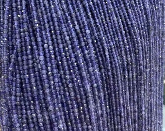 May include: A strand of small, round, faceted amethyst beads. The beads are a deep purple color and are strung on a clear thread. The beads are all approximately the same size and are evenly spaced.