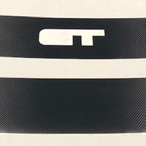 May include: Two black carbon fiber vinyl decals with a white "GT" logo on one decal. The decals are curved and have a textured surface.