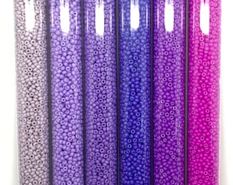 May include: Six small glass tubes filled with 11/0 size round seed beads in various shades of purple. The tubes are labeled with the bead size, color code, and website address. Each tube contains 30 grams of beads.