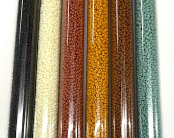 May include: Six small glass tubes filled with 11/0 size seed beads in various matte colors. The colors are black, white, brown, orange, yellow, and blue. The tubes are labeled with the bead size and color, and the text "11/0 Matte Op Coffee Time set/30g ea".