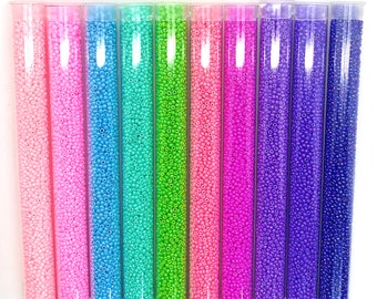 May include: Ten tubes of 11/0 size seed beads in various colors, including pink, blue, green, and purple. The tubes are labeled with the bead size and color code. The text "11/0 Op Luster set 10 colors" is displayed at the top of the image.