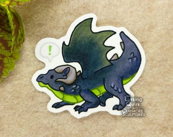 May include: A sticker of a cartoon dragon in blue and green. The dragon has a speech bubble with an exclamation mark. The Lurking Quirk & Claymore Sculptures logo is in the bottom right corner.